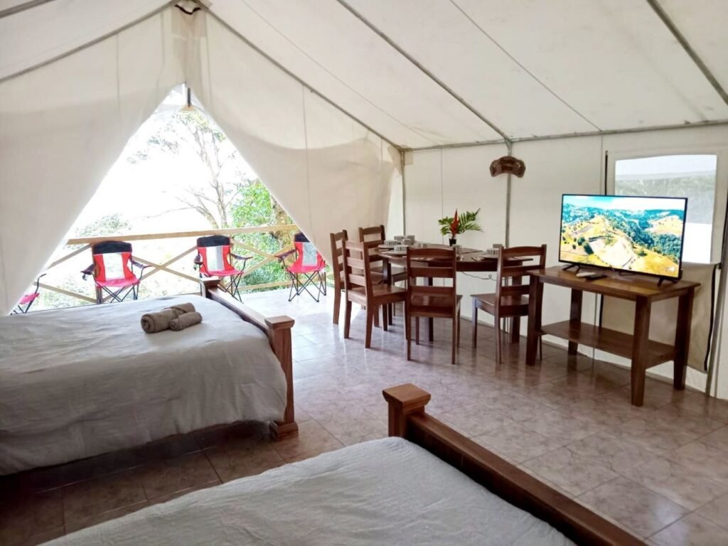 Río Celeste's Best Lodging, Glamping tent interior with smart TV, dining and bed area, tree-top high balcony view
